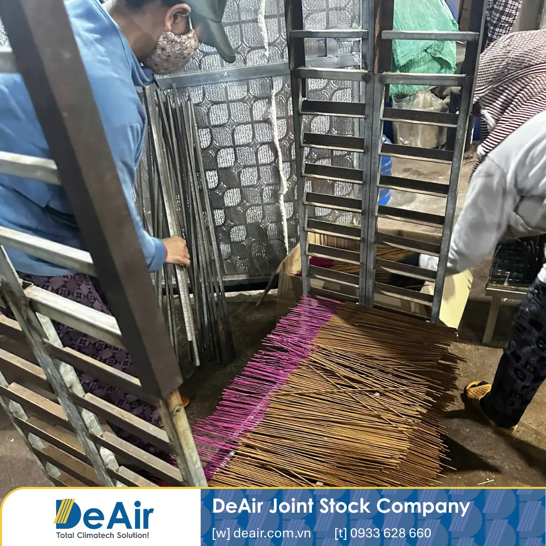 Workers placing incense on specialized drying trays